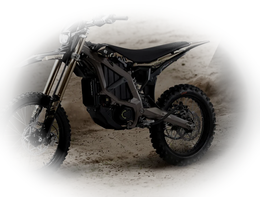 Sur-Ron Ultra Bee HP electric off-road bike with a bronze frame, standing on dirt.